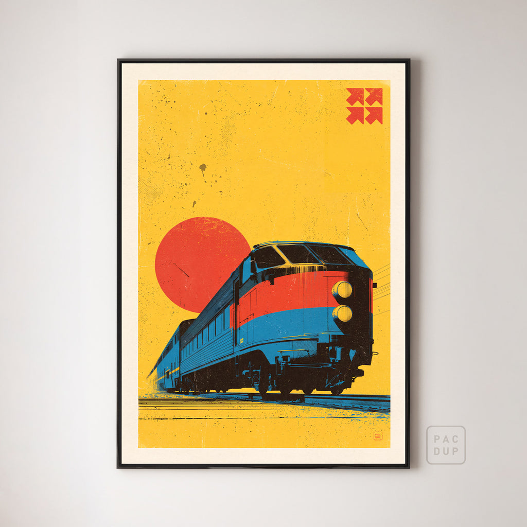 Retro art print of a blue and red locomotive against a yellow background and red sun, displayed in a black frame.
