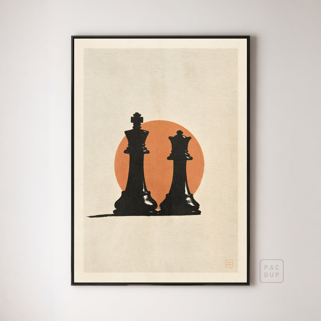 Art print of a black chess king and queen against an orange circle on cream, displayed in a black frame.