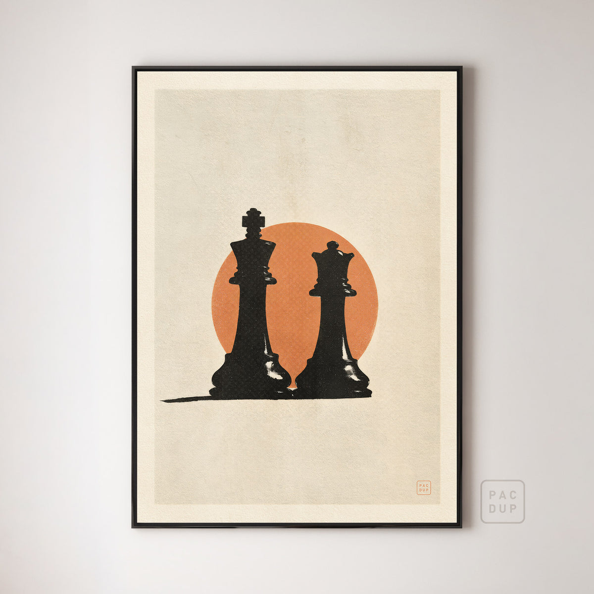 Art print of a black chess king and queen against an orange circle on cream, displayed in a black frame.